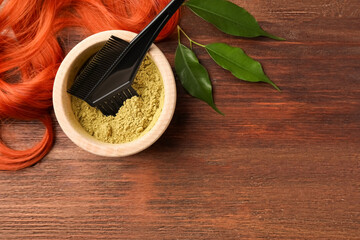 Poster - Bowl of henna powder, brush, green leaves and red strand on wooden table, flat lay with space for text. Natural hair coloring