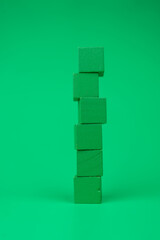 Wall Mural - Tower of empty green blocks with free space for you text on a green background. Vertical image