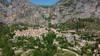 Wall Mural - Smooth 4K footage of Moustiers-Sainte-Marie or Moustiers, a village perched on terraces on the side of a limestone cliff in the Alpes-de-Haute-Provence department in the Provence-Alpes-Côte d'Azur.