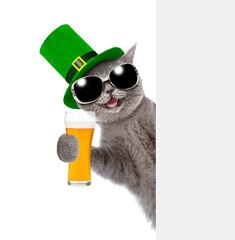 Wall Mural - St. Patricks Day concept. Happy cat holds glass of beer looks from behind empty white banner. isolated on white background