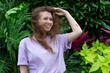 © Евгений Шемякин - Portrait of happy young woman with breathing deep, inhale fresh air on natural background, green wall with leaves, flower in tropical country in garden. Eco, ecological concept.