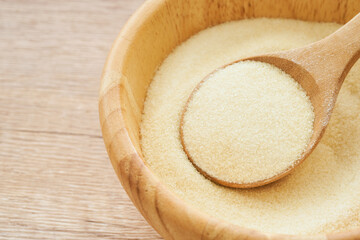 Wall Mural - gelatin powder in wood bowl and spoon on wooden table background. pile of gelatin powder in wood spoon. gelatin powder                                         