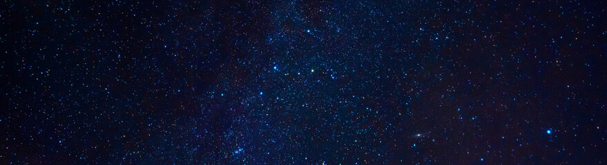 Wall Mural - Astrophotography of a dark blue starry sky with many stars, nebulae and galaxies. Panoramic wide horizontal photo for banner head cover