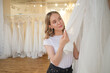 young woman choosing best wedding dress in wedding boutique. Most important wedding day