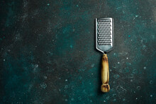 Kitchen Metal Grater For Cheese. On A Dark Green-turquoise Background. Free Space For Text.