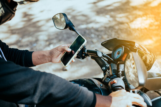 hands of motorcycle man texting on the phone. close-up of motorcyclist texting on the phone. concept