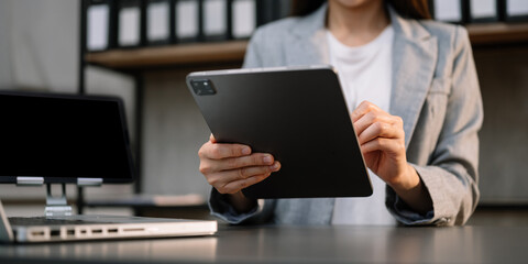 businesswoman hand using smart phone, tablet payments and holding credit card online shopping, omni channel, digital tablet docking keyboard computer at office .