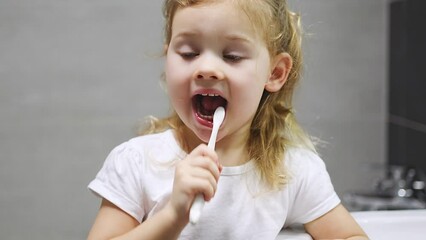 Wall Mural - Happy toddler girl brushing teeth in the bath