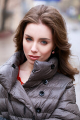 Poster - Portrait of a Young stylish brunette girl in a gray down jacket