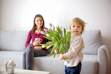 Wall Mural - Beautiful blond boy, giving mother flowers and box with little gift for mothers day