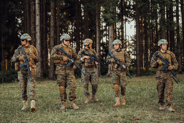 Wall Mural - Soldier fighters standing together with guns. Group portrait of US army elite members, private military company servicemen, anti terrorist squad