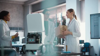 Fototapete - Team of Industrial Specialists Working on Mobile Robot, Using a Laptop. Young Male and Female Engineers in a Lab Discussing an Automated AI Robotic Delivery Assistant, Brainstorming Improvement Ideas