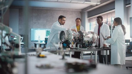 Leinwandbilder - Young Female Black Engineer Leading her Team, Analyzing and Researching How a Futuristic Turbofan Motor Works. Diverse Scientists Developing Innovative Technology in Industrial High Tech Facility