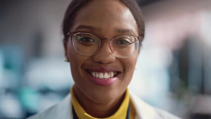 Poster - Portrait Close Up of Young Black Female Specialist Wearing Lab Coat and Glasses Smiling. Professional and Successful Woman Working as an Engineer, Developing High Technology Projects