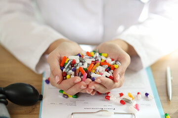 Sticker - Female doctor holds bunch of different medical pills in her hands.