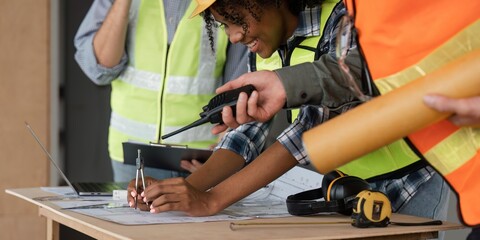 Wall Mural - Architect team working with blueprints for architectural plan, engineer sketching a construction project on table in working site