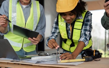 Wall Mural - Architect team working with blueprints for architectural plan, engineer sketching a construction project on table in working site