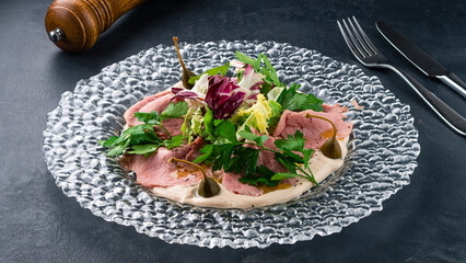 Wall Mural - Italian appetizer Vitello tonnato, pieces of veal with cream sauce and herbs.