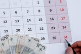 Fototapeta  - Kalendarz z długopisem trzymanym w dłoni wskazujący na ostatni - 31 dzień miesiąca 