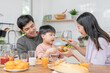 © Shisu_ka - activities together during the holidays. Parents and children are having a meal together during the holidays. Mather prepare milk for son on morning, enjoy, weekend, vacant, family time, happy.
