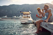 © luckybusiness - young adult caucasian couple sitting at the dock, eating watermelon
