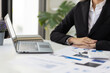 © Wasan - Businesswoman working in the office analyzing and planning a business project on her laptop at her desk.