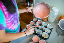 Young Girl Pouring Flavored Cupcake Batter Into The Cups