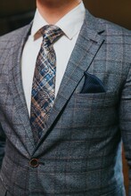 Vertical Shot Of The Torso Of A Man In A Gray Check Suit And White Shirt With Check Paisley Tie