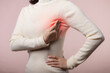 © Jirawatfoto - Woman hands checking lumps on her breast for signs of breast cancer on pink background. Healthcare concept.