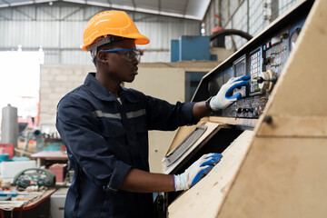 Factory male worker at work in the industry factory, work with CNC machine. Factory engineer male worker maintaining machine in the industrial factory