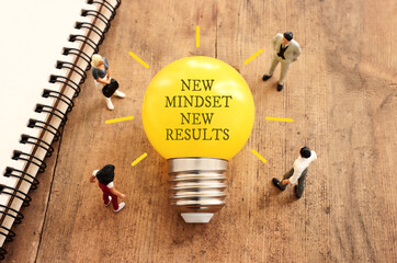 Poster - light bulb with the text new mindset in on wooden table