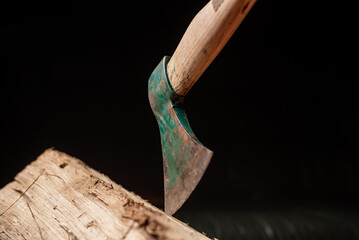 Axe and log on dark background. Firewood harvesting for winter concept.