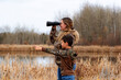 © Saeedatun - A mom and a son are exploring the nature in the park near the lake.