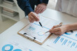 © Parichat - Business sales consultant discussing in data documents at modern office.