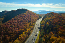 I-40 Freeway Road Leading To Asheville In North Carolina Over Appalachian Mountain Pass With Yellow Fall Forest And Fast Moving Trucks And Cars. Concept Of High Speed Interstate Transportation