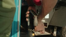 African American Man Tightening Trailer Hitch To Car For Towing