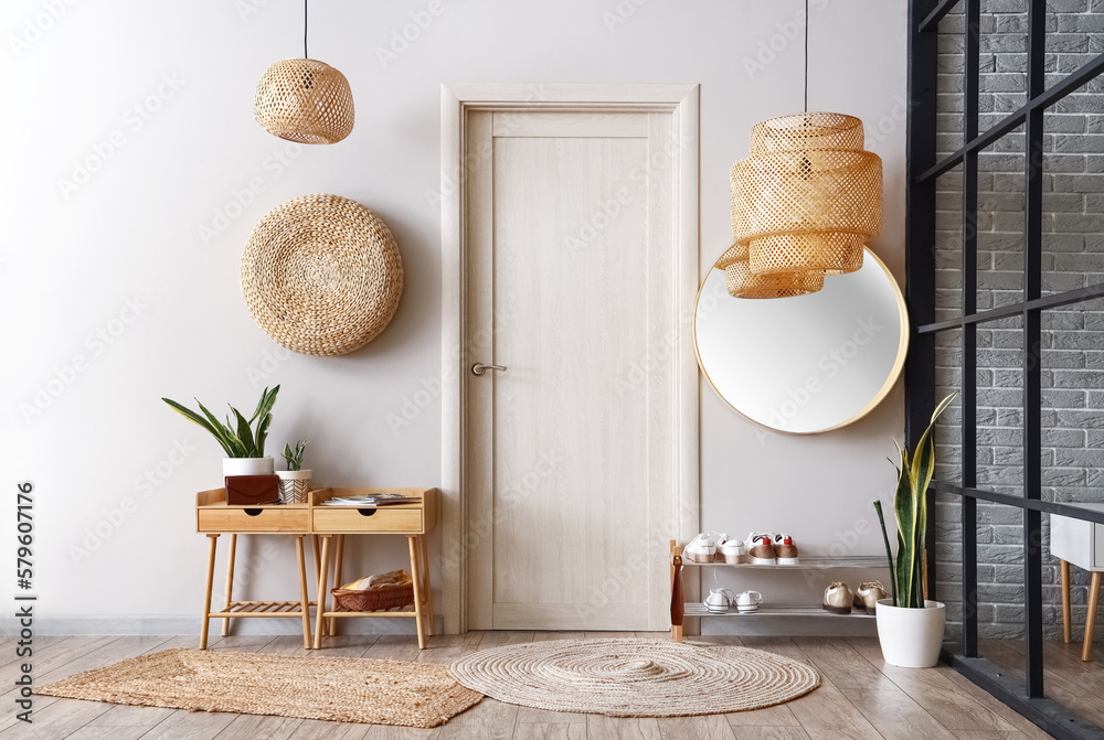 Interior of light hall with tables, shoe stand and door