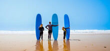 Happy Family With Surfboard On The Beach