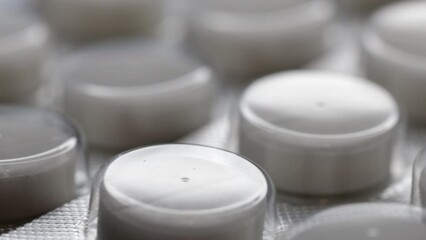 Poster - white pills in a blister are rotated in a circle