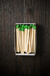 © Cavan Images - Overhead view of green matchsticks in box on wooden table