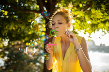 Beautiful Blonde Girl Blowing Bubbles And Having Fun In Park