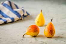 Three Fresh Pears On A Marble Surface
