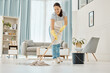 © Anela R/peopleimages.com - Woman cleaning the floor with a mop in the living room in home with a smile. Happy asian cleaner doing housework or job in a clean lounge, hotel room or house while smiling and alone spring cleaning