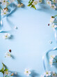 Art Spring flower border on blue background; white spring blossom border