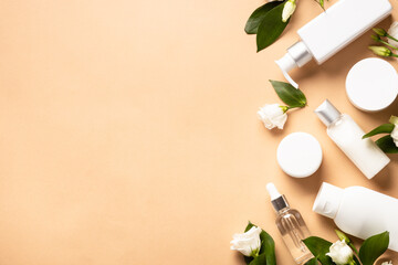 Wall Mural - natural cosmetic products. cream, serum, tonic with green leaves and flowers. flat lay image with co