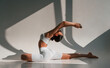 © standret - Doing stretching on the floor. Young caucasian woman with slim body shape is indoors in the studio