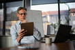 © JustLife - Portrait of businessman in office. Man using digital tablet. Businessman having video call