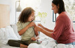 © Kay A/peopleimages.com - Loving mother comforting her daughter with a bandaid in bed, being affectionate and caring at home. Young parent helping her sick child, applying a plaster and bonding, special moments of motherhood