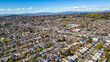 Aerial photos over a community in Vallejo, California with houses, streets, cars and parks on a sunny day in March.