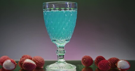 Poster - Bright refreshing drink in transparent glass. Stock clip. Drink with bubbles and ingredients all around. Bright drink in glass in bar atmosphere